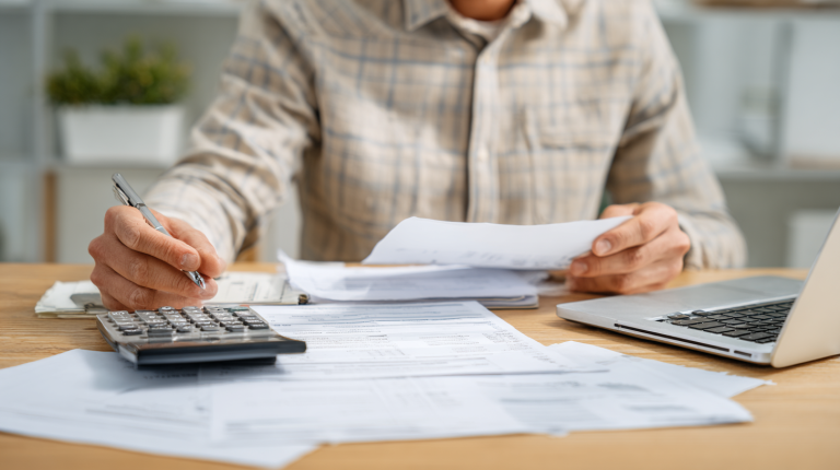 Entrepreneur analysant une comptabilité créances-dettes et des documents fiscaux
